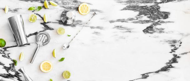 A banner with a set of cocktail tools, lime, lemon, sugar, ice, ingredients for ,top view, marble background, cope space for text - Foto, immagini