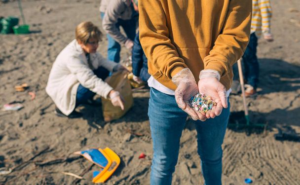 Hände mit Mikroplastik am Strand - Foto, Bild