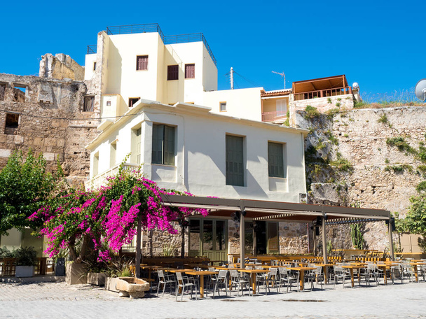 tiiliä kukkia ja pöytiä ja tuolit syrjäyttää kreikkalainen ravintola. pohjimmiltaan kreikkalainen myymälä edessä ravintolarakennus Hania konkreettisia - Valokuva, kuva