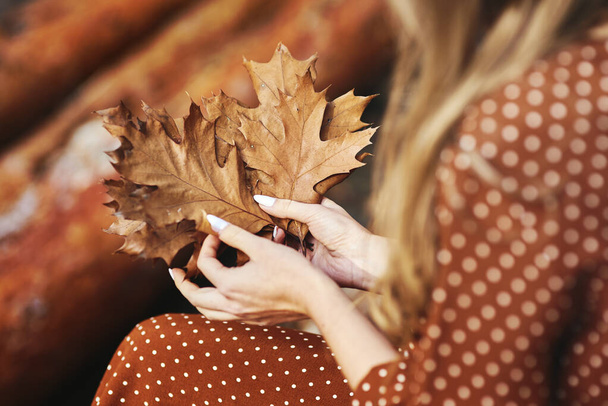 Κοντινό πλάνο της γυναίκας με ένα μάτσο φθινοπωρινά φύλλα - Φωτογραφία, εικόνα