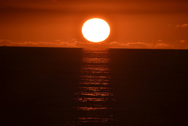 Puesta de sol sobre Tapia de Casariego, en Asturias.Podemos ver cómo el sol está cayendo y escondiéndose junto al mar, hasta que desaparece. - Foto, Imagen