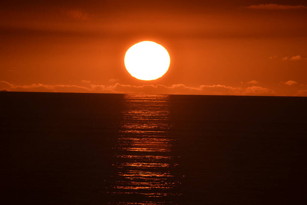 Puesta de sol sobre Tapia de Casariego, en Asturias.Podemos ver cómo el sol está cayendo y escondiéndose junto al mar, hasta que desaparece. - Foto, Imagen
