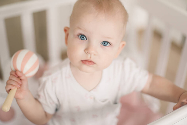 Cute little baby girl playing with toys at home or nursery. Happy healthy child having fun with colorful toy. - 写真・画像