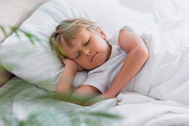 selective focus of child sleeping on white bedding in morning - Photo, Image