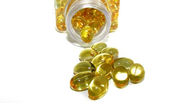 Kabeljauw leverolie of visolie gel capsules op witte achtergrond. Bevat omega 3-vetzuren, EPA, DHA - Foto, afbeelding