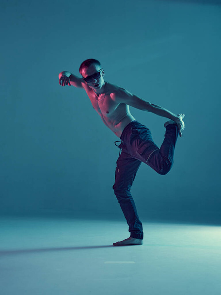 Stylish young guy breakdancer dance hip-hop without shirt in neon blue light. Dance school poster - Fotó, kép