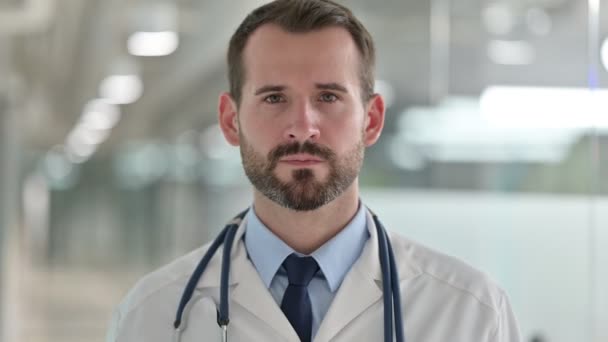 Porträt eines freundlichen männlichen Arztes, der per Videoanruf spricht  - Filmmaterial, Video