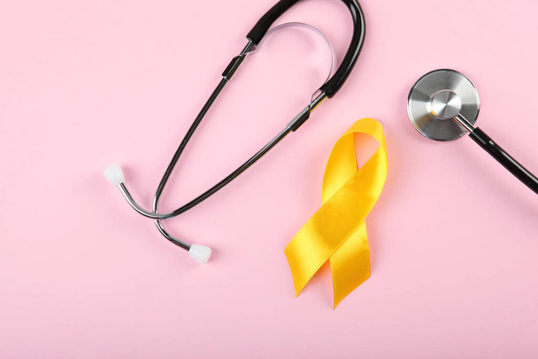 yellow ribbon symbolizing cancer in children top view - Fotografie, Obrázek
