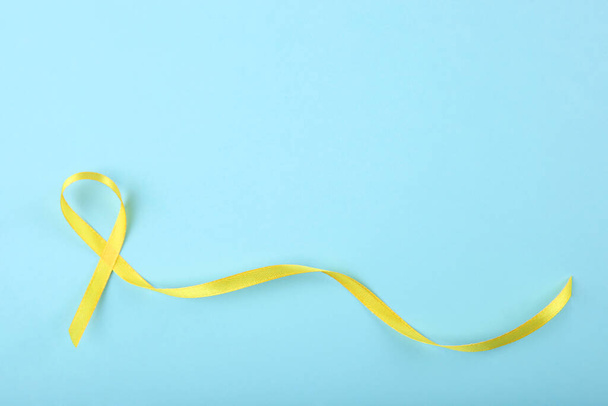 κίτρινη κορδέλα που συμβολίζει τον καρκίνο στα παιδιά top view - Φωτογραφία, εικόνα