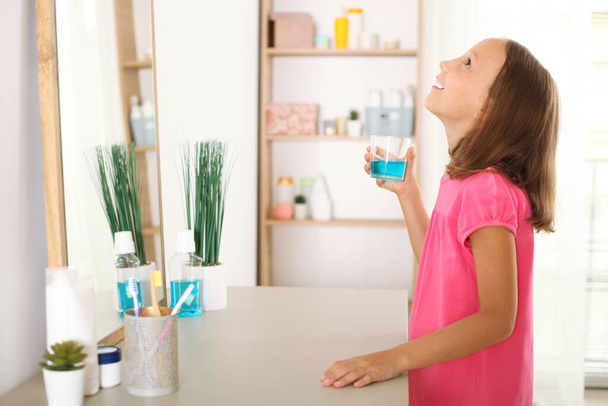 the child is rinsing the mouth with a mouthwash. Oral health in children, prevention of dental diseases - 写真・画像