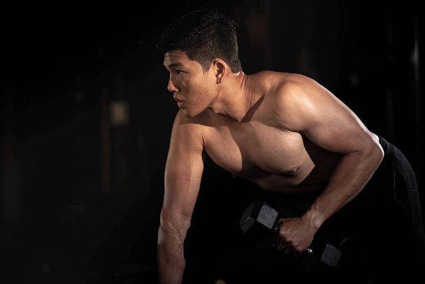 Hombre guapo levantando mancuerna, haciendo ejercicio para el músculo buit, ajuste y cuerpo firme, posando modelo - Foto, imagen