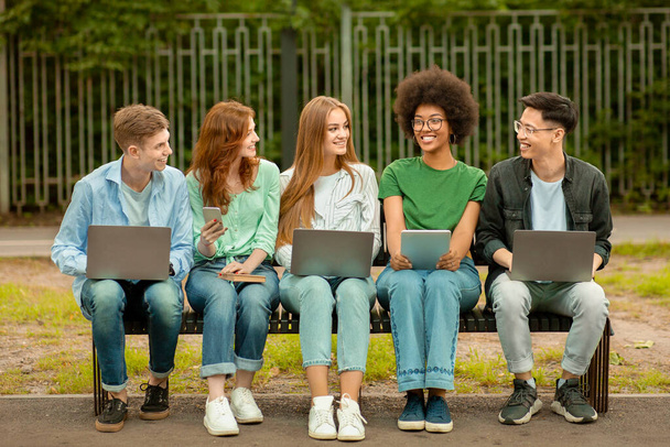 Ομαδικό σχέδιο. Πολυφυλετικές Φοιτητές Κολλεγίου Μελετώντας Έξω Με Φορητούς Υπολογιστές Και Ψηφιακή Ταμπλέτα - Φωτογραφία, εικόνα