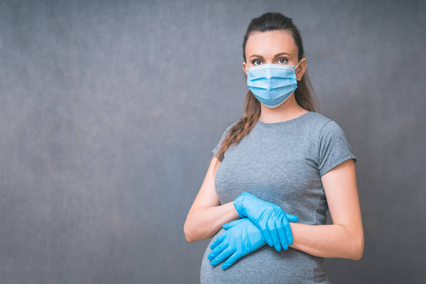 Pregnant Woman in blue gloves and Medical Face Mask against flu and viruses. Healthcare concept. Pregnancy And Infection concept. - Foto, Imagem