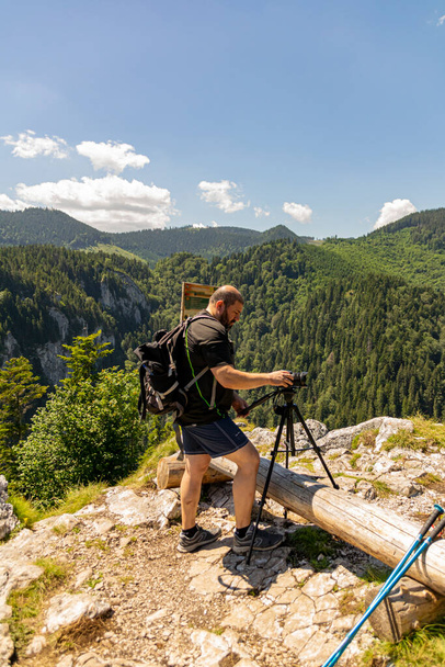 фотограф ходить фотографуючи пейзаж з фотоапаратом, глибоко в гори
 - Фото, зображення