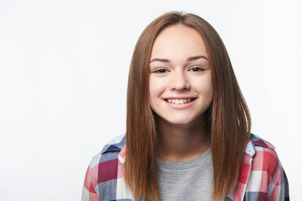 Closeup of happy smiling teen girl looking at camera, studio portrait - Fotó, kép