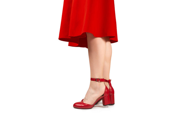 Femme en robe rouge et en sandales rouges rétro sur talons isolés sur fond blanc.  - Photo, image