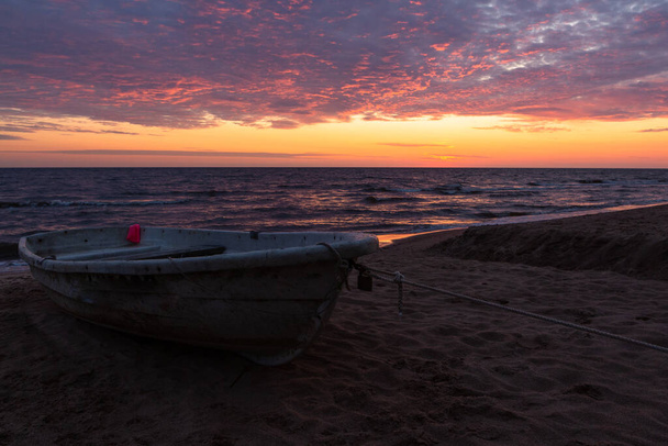 Σκάφος στην παραλία κατά τη διάρκεια φωτεινό ηλιοβασίλεμα - Φωτογραφία, εικόνα