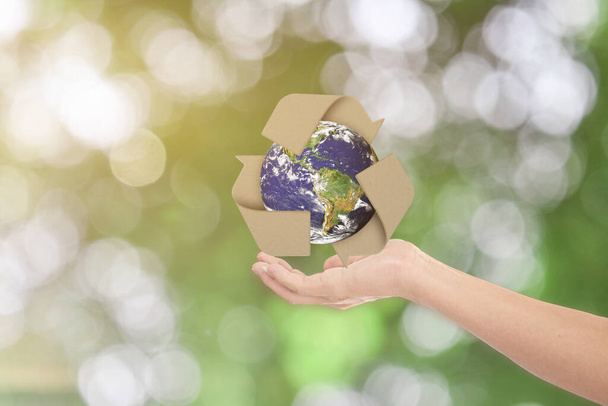 Concept de journée mondiale de la Terre. Homme montrer la main tendue avec la Terre et recycler symbole sur fond bokeh vert. Éléments de cette image fournis par la NASA - Photo, image