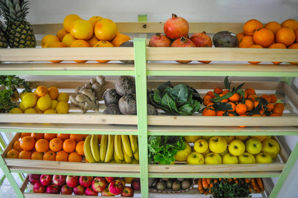 Freash organic fruit and vegetable shop naturally arranged on wooden shelves. - Photo, Image