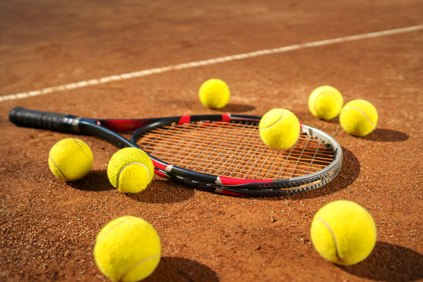 Racchetta e palline da tennis sparse sul campo - Foto, immagini