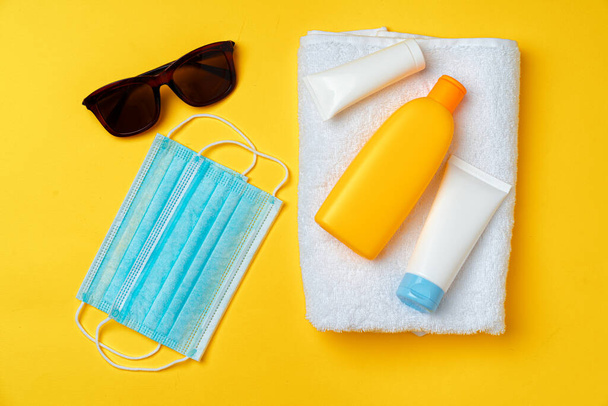 Sunscreen cream and protective mask. Coronavirus summer concept - Фото, изображение