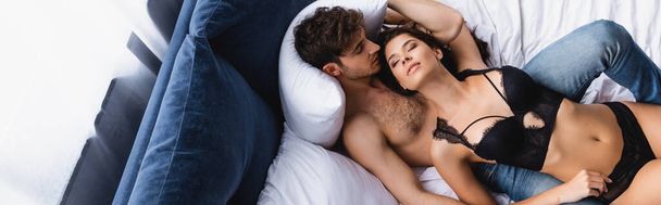 vista superior de la sexy pareja acostada en la cama, plano panorámico - Foto, imagen