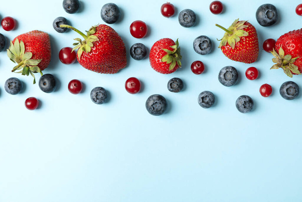 Flat lay with fresh berries on blue background, top view - Photo, Image