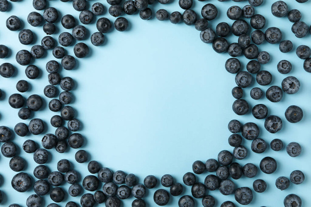 Circle made of blueberries on blue background, space for text - Photo, image