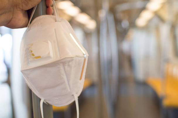 Biała maska służy do zakrywania nosa, ochrony przed wirusami podczas podróży autobusem lub pociągiem elektrycznym.. - Zdjęcie, obraz