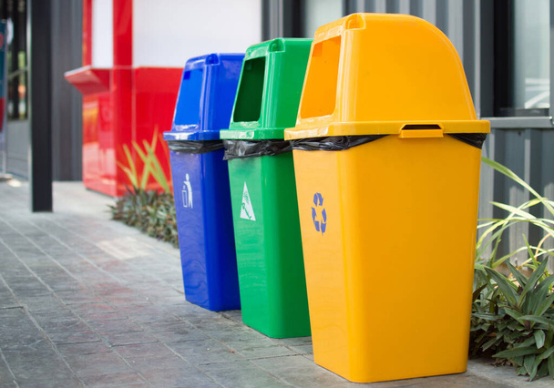 Ein grüner, gelber, blauer Mülleimer befindet sich vor dem Badezimmer für Sauberkeit. - Foto, Bild