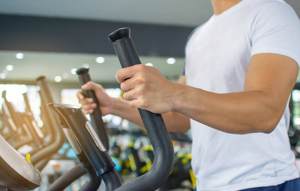 Erkekler sabahları spor salonunda kol ve bacak egzersiz makineleri kullanır.. - Fotoğraf, Görsel