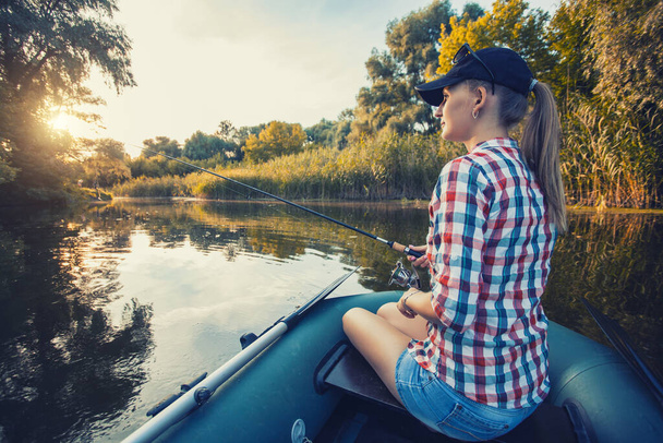 Cute woman is fishing with rod on a summer lake - Fotografie, Obrázek