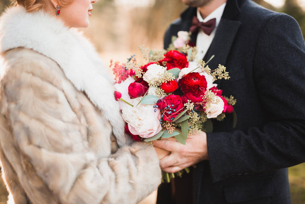 Perfect wedding couple holding luxury bouquet of flowers - Fotó, kép