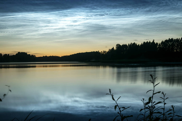 Gölü kaplayan beyaz gümüş bulutlu güzel bir gece manzarası bulanık bir ön plan göl suyunda büyüleyici bulut yansımaları, yaz gecesi - Fotoğraf, Görsel