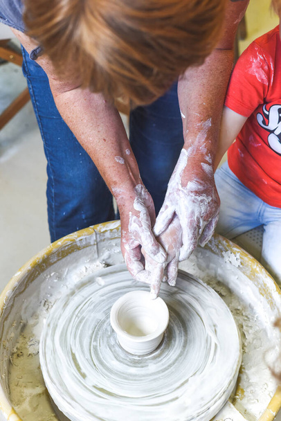 Crianças fazendo cerâmica durante a aula de cerâmica com argila
 - Foto, Imagem