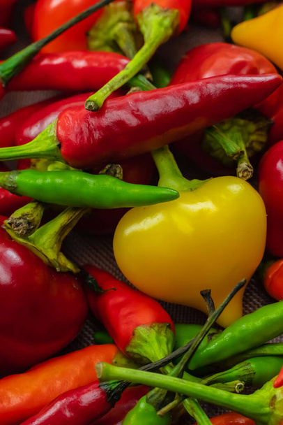 hot yellow round pepper on a background of red long pod background bright - 写真・画像