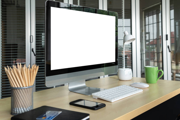 Empty computer monitor screen for design mock up template in modern small office interior or home office. Stylish workplace for creative occupation. - Foto, Bild