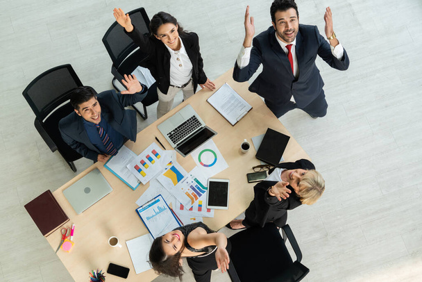 Successful business people celebrate together with joy at office table shot from top view . Young businessman and businesswoman workers express cheerful victory showing success by teamwork . - Photo, image