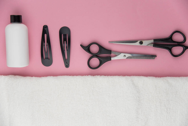Herramientas profesionales de peluquería con espacio para copiar. Equipo de estilista sobre fondo rosa. Tijeras, cepillo, cepillo para el cabello, bálsamo plano vista superior. - Foto, imagen