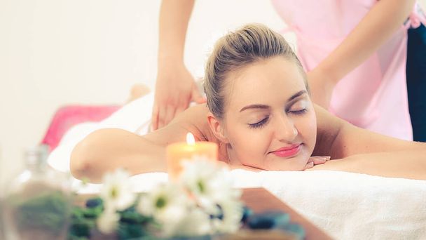 Розслаблена жінка отримує масаж спини в розкішному спа-центрі з професійним масажистом. Концепція оздоровлення, оздоровлення та релаксації
. - Фото, зображення
