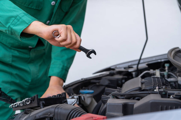 Professional mechanic hand providing car repair and maintenance service in auto garage. Car service business concept. - Фото, зображення