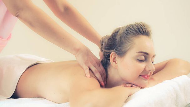 Relaxed woman getting back massage in luxury spa with professional massage therapist. Wellness, healing and relaxation concept. - Photo, Image