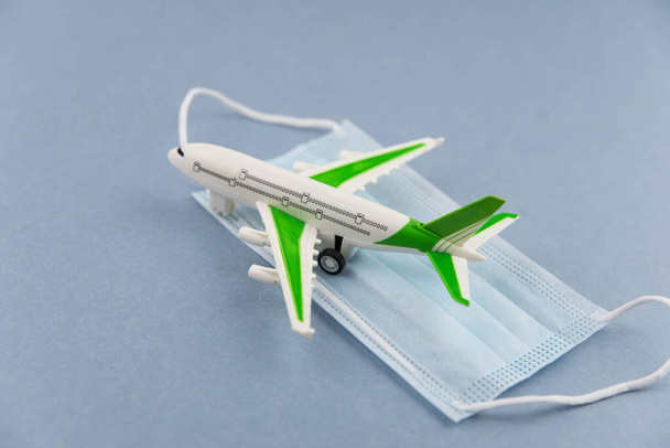 Safe travels concept. Plane with surgical medical mask. Safety flight and travel during quarantine and lockdown. - Foto, Imagen