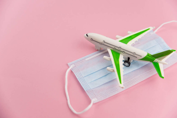 Safe travels concept. Plane with surgical medical mask. Safety flight and travel during quarantine and lockdown. - Fotografie, Obrázek