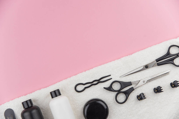 Herramientas profesionales de peluquería con espacio para copiar. Equipo de estilista sobre fondo rosa. Tijeras, cepillo, cepillo para el cabello, bálsamo plano vista superior. - Foto, imagen