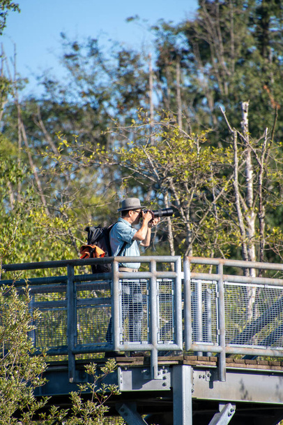 Знімок азіатського чоловіка, який фотографує з вершини оглядової вежі в парку. Ванкувер до Канади - Фото, зображення