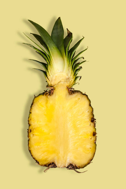 Полусвежий ананас на жёлтом фоне. Летняя концепция. Плоский, вид сверху. - Фото, изображение