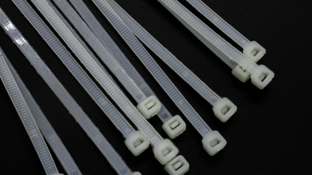 Een kabelbinder, stropdas of stropdas is een veelgebruikt bevestigingselement voor het bevestigen of bundelen van kabels. - Foto, afbeelding