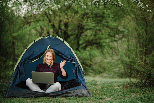 Communicate with relatives, family online on laptop in tent in nature. Female briefing the team at the conference or remote work consultation, woman worker speak talk on video call with colleagues. - Fotografie, Obrázek