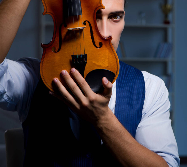 Young musician man practicing playing violin at home - Photo, Image